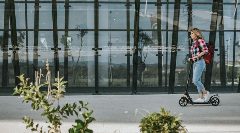 College student on scooter in front of university